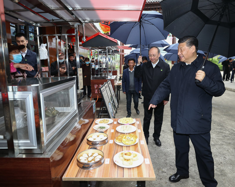 3月22日至25日，中共中央总书记、国家主席、中央军委主席习近平在福建考察。这是23日下午，习近平在三明沙县夏茂镇俞邦村考察时，在小吃摊边同乡亲们亲切交谈。新华社记者 鞠鹏 摄